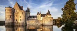 Château aux tours arrondies au milieu d'une rivière dans les Pays de la Loire