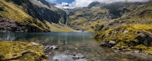 Lac de montagne dans l'Ariège l'été avec les montagnes des Pyrénées en fond