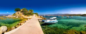 Ponton rejoignant une île corse au milieu de l'eau transparente de la Méditerranée