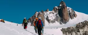 Randonneurs au milieu des montagnes enneigées des Pyrénées sous le ciel bleu