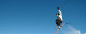 Skieur sautant au-dessus d'une piste de neige en montagne