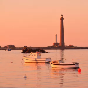 Bateaux amarrés devant le phare de l'Île Vierge au coucher de soleil