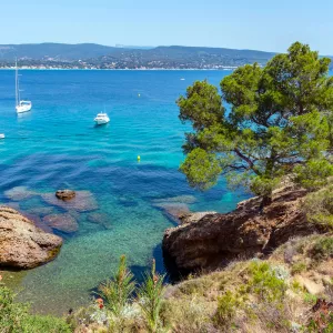 Crique entourée de rochers avec quelques bateaux sur la Mer Méditerranée