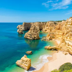 Plage de sable blond de la côte sud du Portugal au milieu des falaises et de l'océan turquoise