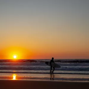 Surfer sur les plages des Landes sortant de l'eau au coucher de soleil