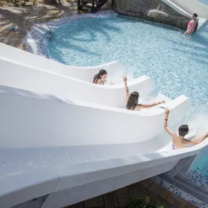 Enfants glissants de toboggans aquatiques dans une piscine de camping