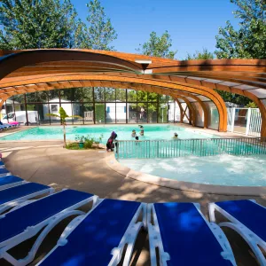 Piscine couverte avec des enfants jouant dans l'eau chauffée du camping La Marina à Messanges dans les Landes