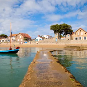 Ponton au bord d'une plage de la côte vendéenne donnant sur un village