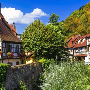 Village alsacien avec des maisons à colombages et une rivière qui traverse la rue