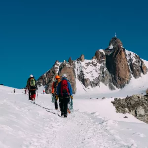 Randonneurs au milieu des montagnes enneigées des Pyrénées sous le ciel bleu