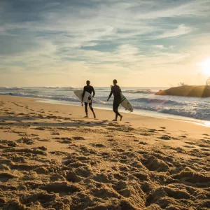 Surfeurs sur le sable à la golden hour 