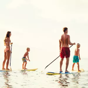 Une famille en stand up paddle sur un lac