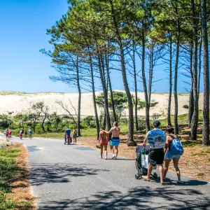 Vacanciers marchant sur la promenade qui donne accès à la plage depuis le camping Le Vieux Port à Messanges dans les Landes