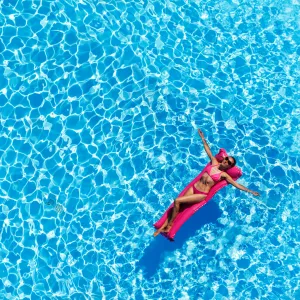 Vacancière sur un matelas gonflable au milieu d'une piscine de résidence Resasol