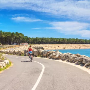 la-palmyre-charente-maritime-nouvelle-aquitaine-france-campings-Coastal landscape - view of the Atlantic coast with a woman cyclist near the town of La Palmyre, the Nouvelle-Aquitaine-resasol-vacances-loisirs-evenements