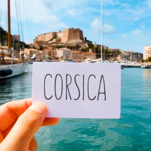 corsica écrit sur une carte face au port en bord de mer en corse à bonifacio avec resasol pour vos vacances entre personnes de confiances