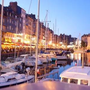Honfleur et son port au crépuscule en Normandie dans le Calvados avec les restaurants qui semblent complets