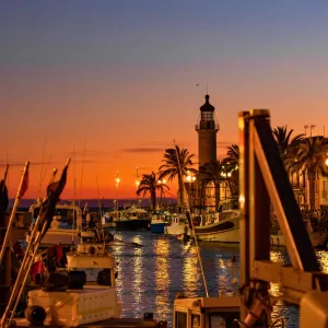 RESASOL FRANCE LE-GRAU-DU-ROI le port et le phare du bord de mer pendant le coucher du soleil avec les couleurs chaudes oranges et rouges de la fin de journée