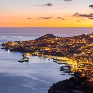 RESASOL PORTUGAL coucher de soleil sur Funchal en Madeira avec la ville en bord de mer illuminée grâce à son éclairage