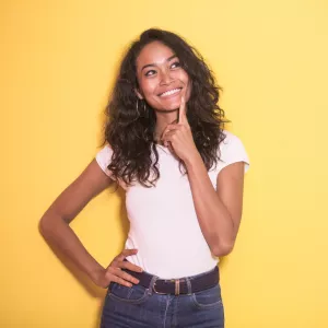 portrait d'une jolie femme indienne d'Asie qui sourit pendant qu'elle pense aux activités qu'elle pourrait faire grâce aux inspirations du catalogue du groupe RESASOL pendant ses congès en famille avec ses enfants