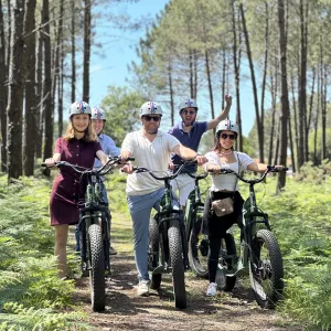 Groupe en trottinette électrique trop contents d'être dans la forêt des Landes entourés par les fougères et la végétation locale pour découvrir toute la beauté du terroir de la Gascogne du Sud-Ouest Atlantique de la France.
